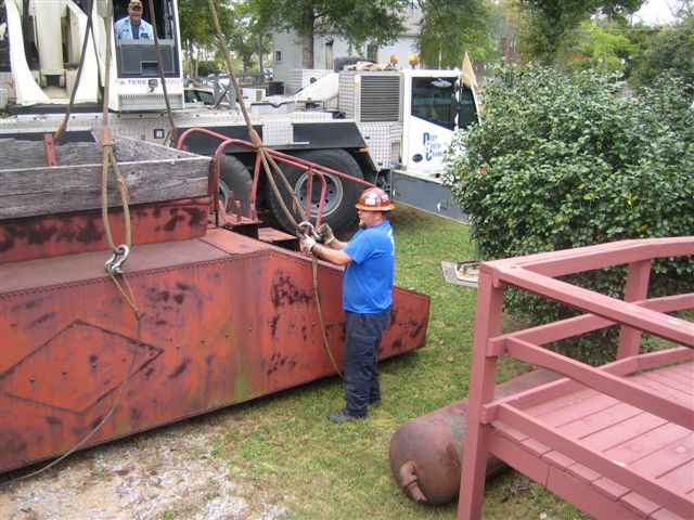 The man on the ground has important work to do, making certain the shackles are tight and securely in place.