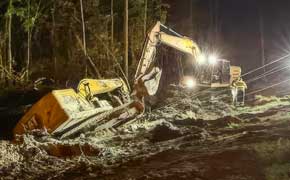 The Big Sink: Cat Excavator Nearly Disappears Into Soft Ground Along Highway 29